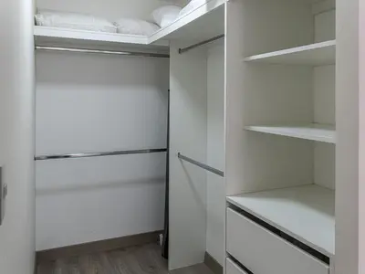 a walk in closet with white shelves and a ceiling at Cozy 2BR Loft in the Heart of Miraflores in Lima