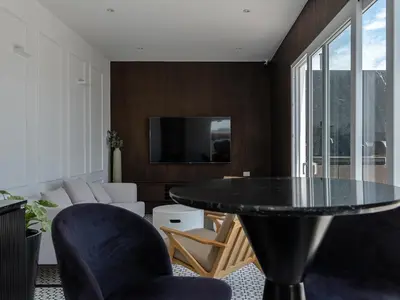 a living room with a glass table and chairs at Cozy 2BR Loft in the Heart of Miraflores in Lima