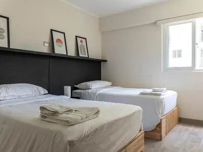 a bedroom with two beds and a window at Cozy 2BR Loft in the Heart of Miraflores in Lima