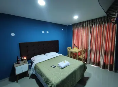 a bedroom with a bed with blue walls and a window at Inti Llaqta Hotel & Suites in Lima