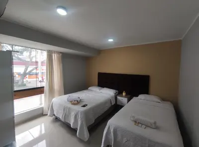 a bedroom with two beds and a window at Inti Llaqta Hotel & Suites in Lima
