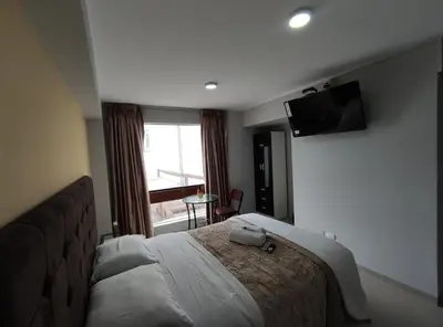 a hotel room with a bed and a flat screen tv at Inti Llaqta Hotel & Suites in Lima