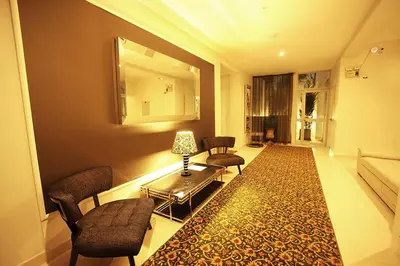 a living room with chairs and a table and a rug at LimaQ Hotel in Lima