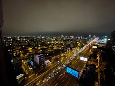 a city at night with cars on a busy street at Beautiful loft at heart of Lima in Lima