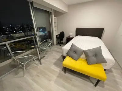 a bedroom with a bed with a yellow bench and chairs at Beautiful loft at heart of Lima in Lima