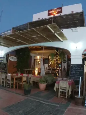a restaurant with tables and chairs and a sign at Bamboo Lodge Paracas in Paracas