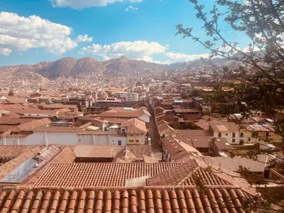 a city with roofs and mountains in the background at Saqray Hostel in Cusco