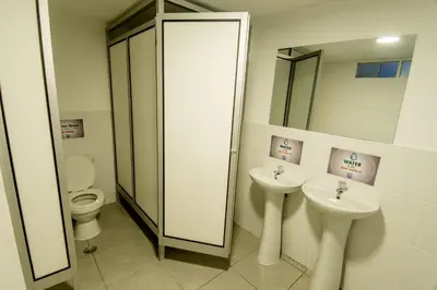 a bathroom with two sinks and a mirror and a toilet at Casa Machu Picchu Hostel in Machu Picchu