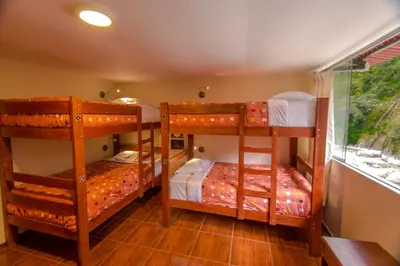 two bunk beds in a room with a window at Casa Machu Picchu Hostel in Machu Picchu
