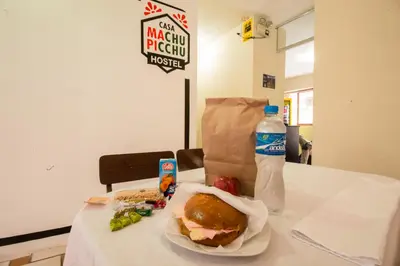 a table with a sandwich and a bottle of water at Casa Machu Picchu Hostel in Machu Picchu