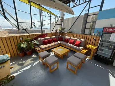 a patio with a couch and chairs and a table at SG Paracas Hostel in Paracas