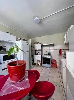 a kitchen with a red table and a potted plant at Siempre Listo in Lima