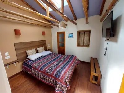 a bedroom with a bed and a flat screen tv at Mirador de la Ñusta in Cusco