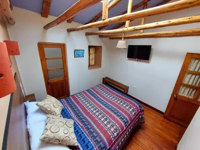 a bedroom with a bed in a room with wooden floors at Mirador de la Ñusta in Cusco