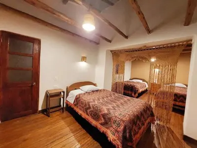 a bedroom with two beds in a room with wooden floors at Mirador de la Ñusta in Cusco