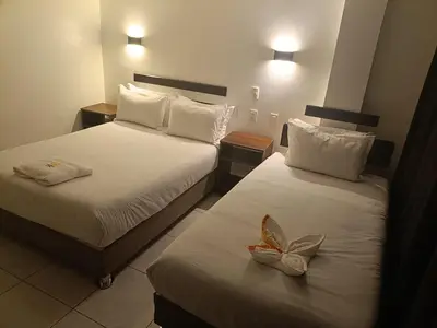 a hotel room with two beds with shoes on them at PAKARINA HOTEL in Machu Picchu