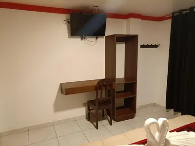 a room with a desk and a tv on the wall at PAKARINA HOTEL in Machu Picchu