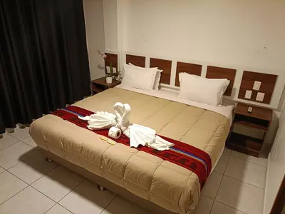 a bedroom with a bed with a flower on it at PAKARINA HOTEL in Machu Picchu