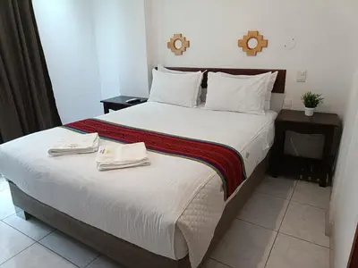 a bedroom with a large bed with two towels on it at PAKARINA HOTEL in Machu Picchu
