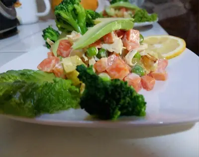 a white plate with broccoli and other food on it at Refugio de Mery Lucmabamba in Sahuayacu