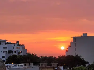a sunset over a city with buildings and trees at Moderno departamento cerca al malecón in Lima