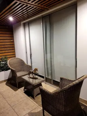 a cat sitting on a table next to two chairs at Moderno departamento cerca al malecón in Lima