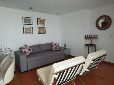 a living room with a couch and two chairs at Moderno departamento cerca al malecón in Lima