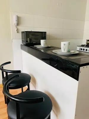 a black counter with a microwave and a black chair at 807. Departamento entero en Chorrillos in Lima