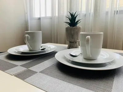 two coffee cups and plates on a table at 807. Departamento entero en Chorrillos in Lima