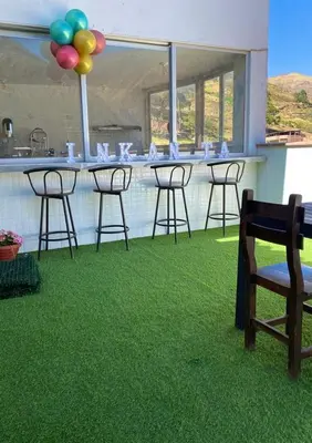 a group of chairs and a bar with green grass at Hotel Sol de Canta in Canta