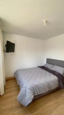 a bed in a bedroom with a tv on the wall at Hotel Sol de Canta in Canta