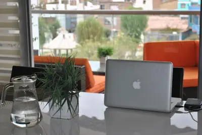 a laptop computer sitting on a table with a plant at CasaHotel El Tambo Huancayo in Huancayo