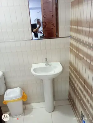 a bathroom with a sink and a toilet and a mirror at Hotel Grand Paradise Marcona in San Juan de Marcona