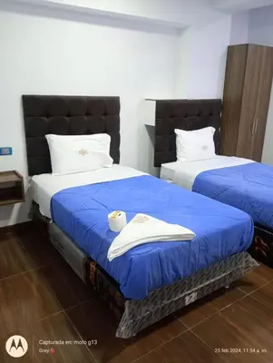 two beds in a room with blue comforter at Hotel Grand Paradise Marcona in San Juan de Marcona