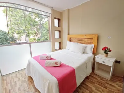 a bedroom with a bed with two towels on it at Hotel Sand and Lake in Ica