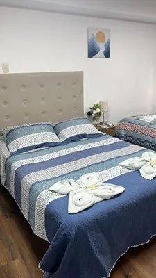 two beds with towels on them in a bedroom at Harmony Inn Miraflores in Lima