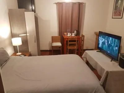 a bedroom with a bed and a flat screen tv at Nico Homes in Cusco
