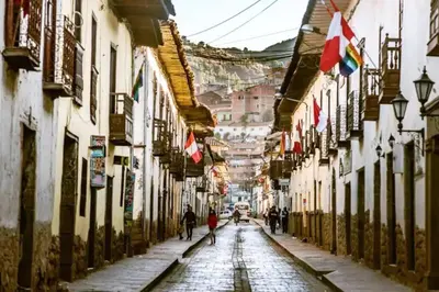 an empty street in an old town with people walking down it at Nico Homes in Cusco