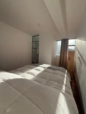 a bedroom with two beds and a large window at Vertigo Climbing Hostel in Urubamba