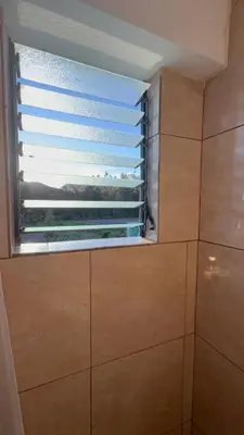 a window in a bathroom with a window blind at Vertigo Climbing Hostel in Urubamba