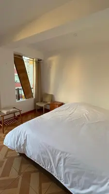 a bedroom with a white bed and a window at Vertigo Climbing Hostel in Urubamba