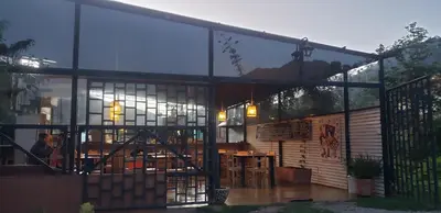 a house with glass walls and a patio at Vertigo Climbing Hostel in Urubamba