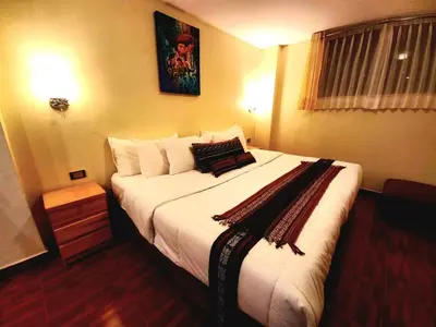 a bedroom with a large bed with white sheets and pillows at Hotel Humantay lodge Ollantaytambo in Ollantaytambo