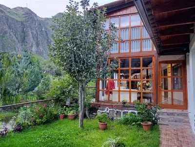 a house with a tree in front of it at Hotel Humantay lodge Ollantaytambo in Ollantaytambo