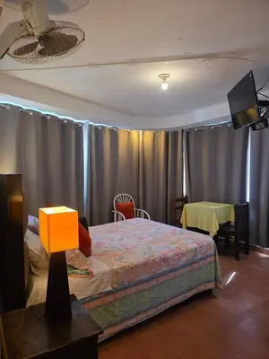 a bedroom with a bed and a tv and curtains at Ollanta Rooftop Adults only in Ica