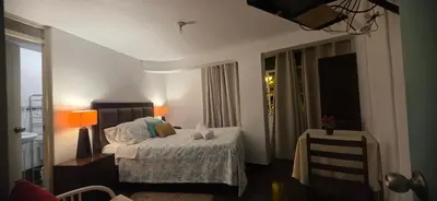 a bedroom with a bed and a table and a window at Ollanta Rooftop Adults only in Ica