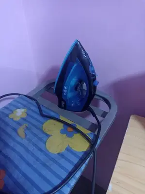 a blue iron sitting on top of a table at Mi Casa Bonita con baño privado y ducha caliente in Lima