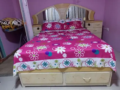 a bed with a pink bedspread with flowers on it at Mi Casa Bonita con baño privado y ducha caliente in Lima
