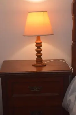 a lamp on a wooden table next to a bed at ROOM Lima House centro in Lima