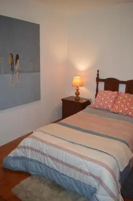 a bedroom with a bed and a lamp and a painting at ROOM Lima House centro in Lima